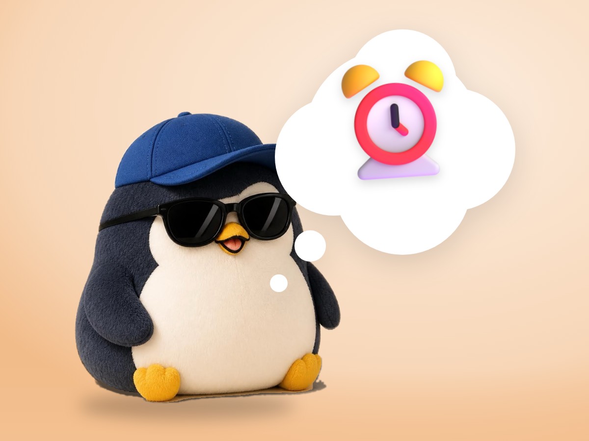 A chubby corduroy and felt penguin napping sitting up next to a small classic twin-bell alarm clock