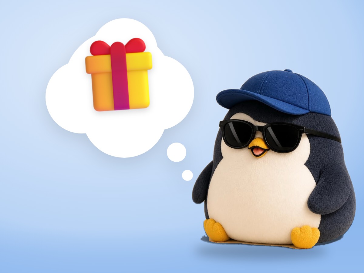 A brushed mohair penguin jumping with joy next to a small wrapped gift box