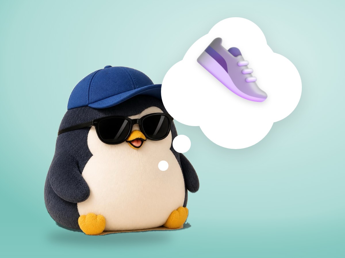 A chubby boucle wool penguin gently looking down at a pair of small worn red sneakers