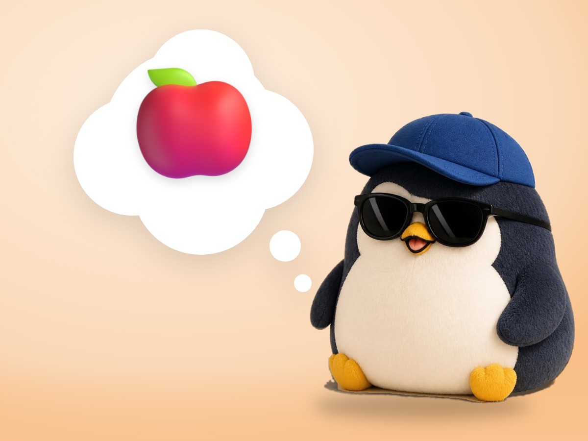 A chubby hand-embroidered felt penguin happily taking a small bite of a shiny red apple