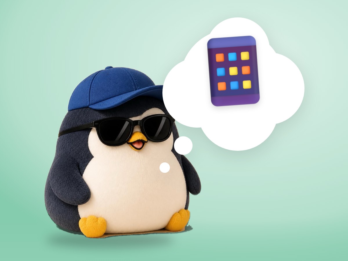 A soft felted wool penguin at a small wooden desk, glancing sideways at a smartphone lying face up next to an open book