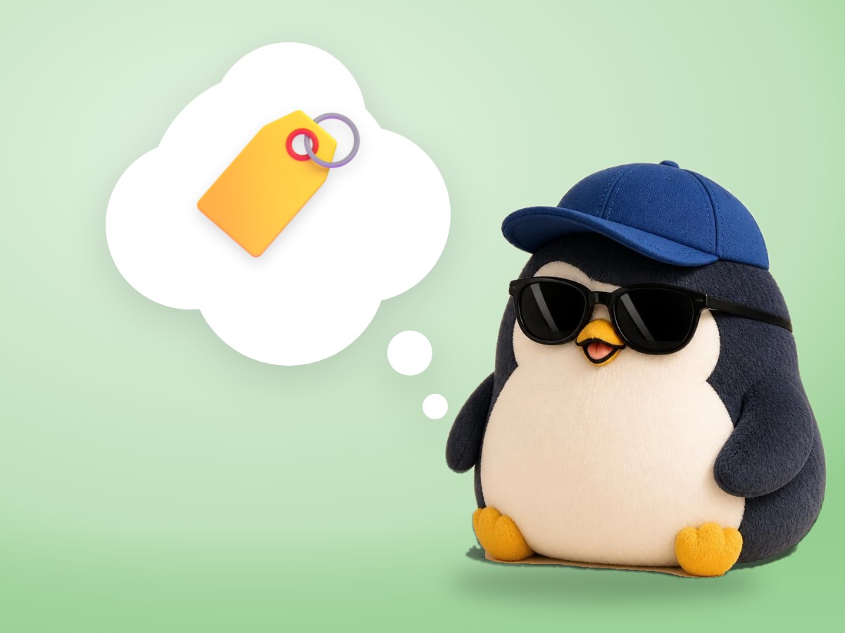 A felted wool penguin hugging a small soccer ball that has a little paper name tag tied to it