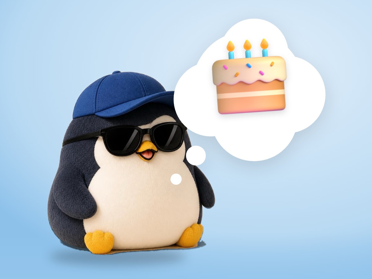 A chubby hand-embroidered felt penguin holding a small note card next to a real strawberry shortcake