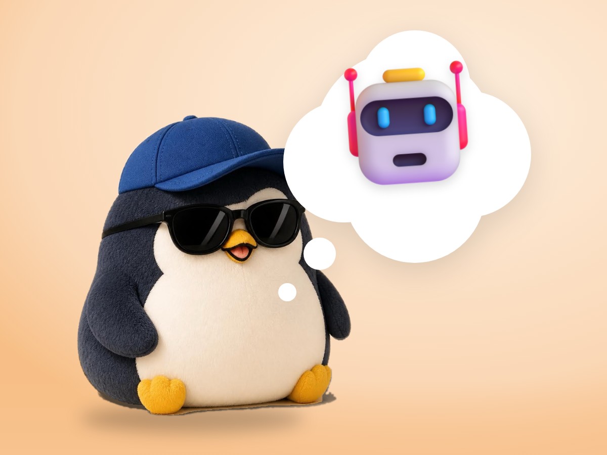 A chubby chenille yarn penguin smiling beside a real small tin wind-up toy robot