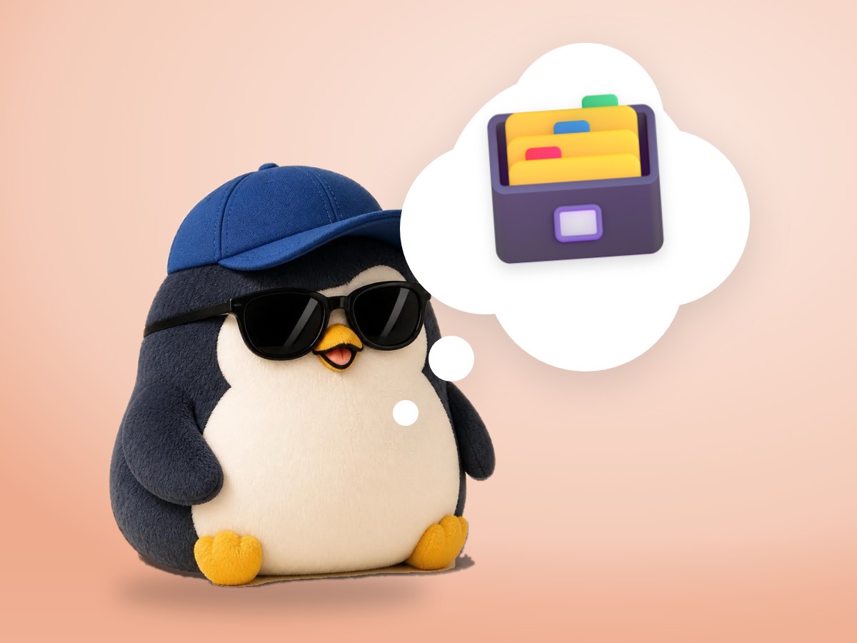 A chubby round penguin made of layered cut paper sorting blank index cards into a small wooden card box