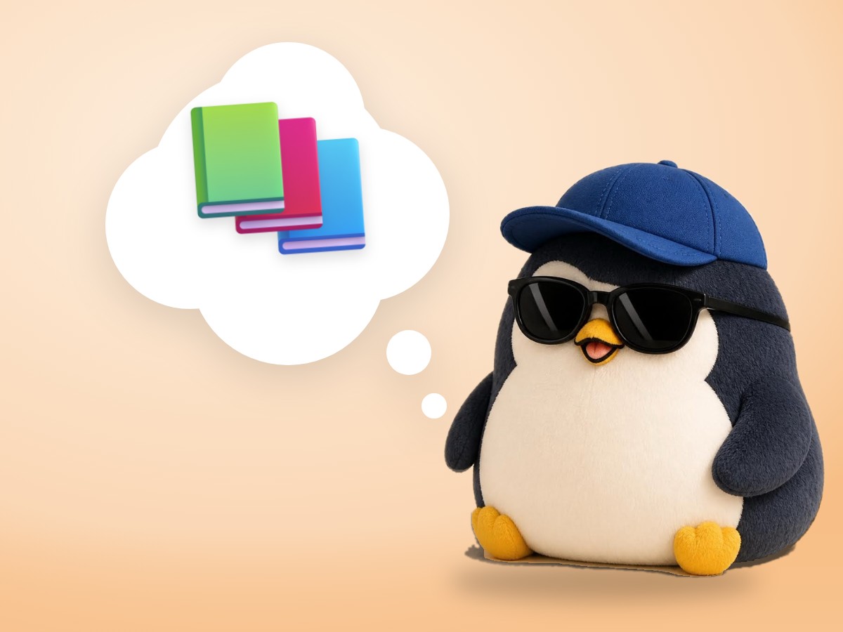 A chubby layered cut paper penguin sitting on top of a real stack of three hardcover books like a small mountain