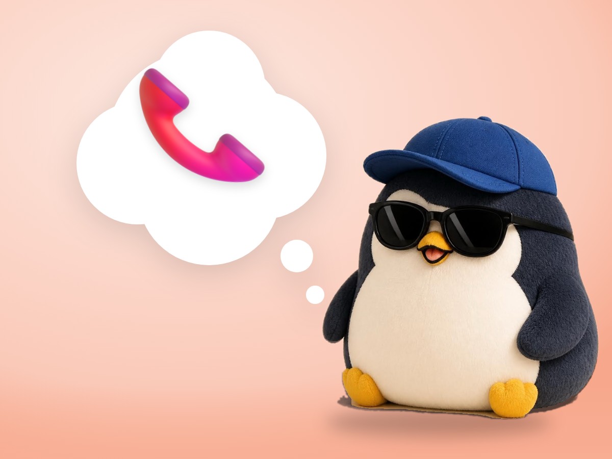 A chubby boucle wool penguin happily holding the handset of a real red vintage telephone